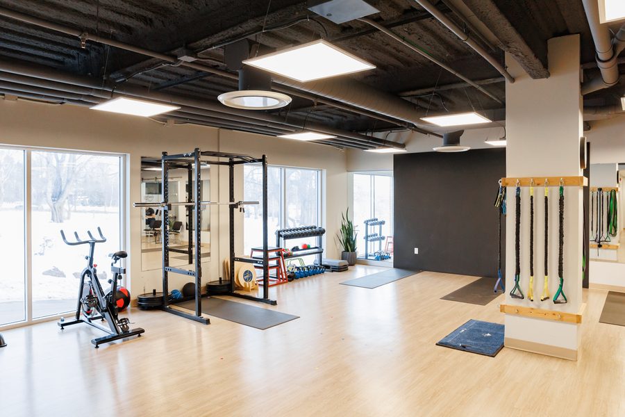 Training floor with squat rack, spin bike, and free weights