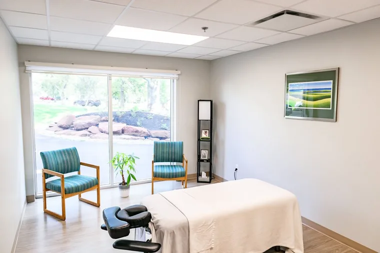 Massage therapy room with seating and natural light