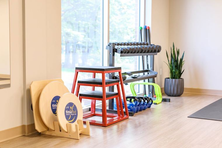 Plyometric boxes, foam rollers, and dumbbells on the training floor