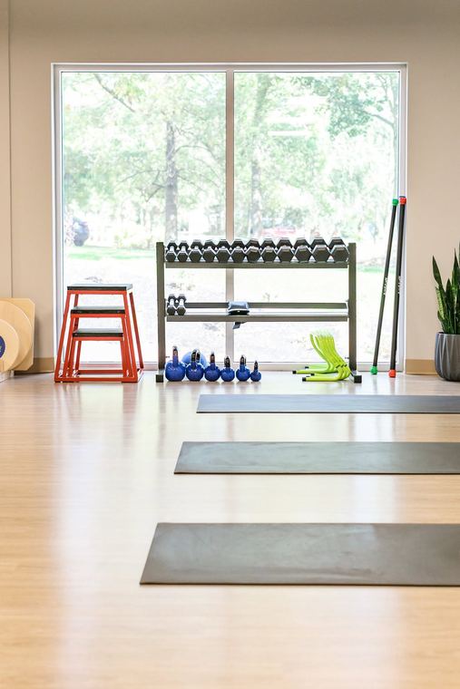 Plyometric boxes, kettlebells, and mats beside the window